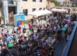 Vista panorámica del público y los puestos del V Mercadillo del Comercio Local en la Plaza de España de Zuera